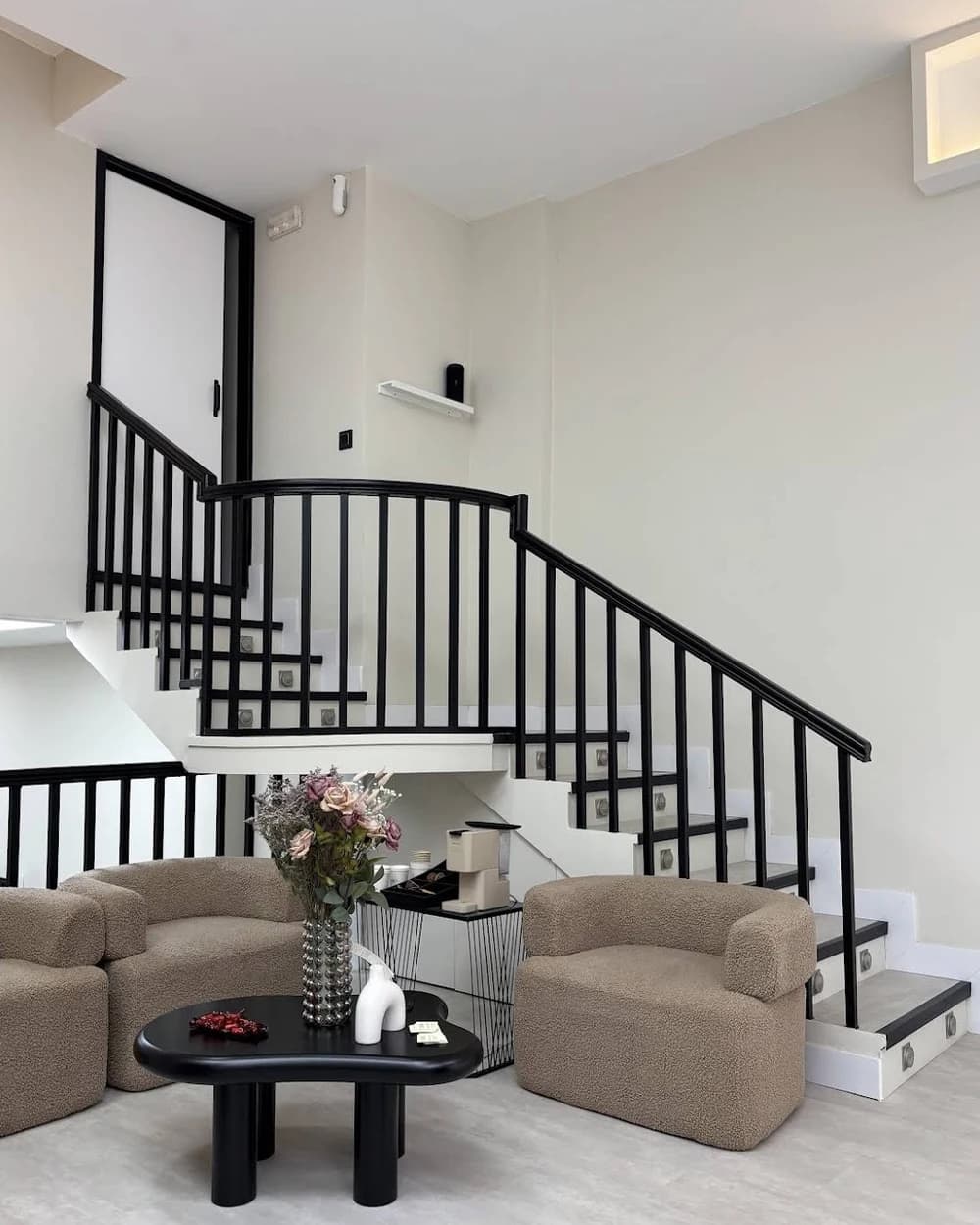 Sala de espera de Luméa Studio con butacas y escalera negra
